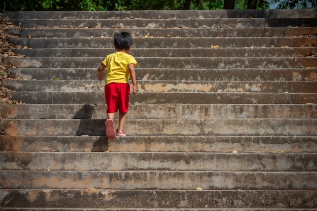 Photo boy walking up the concrete stairs