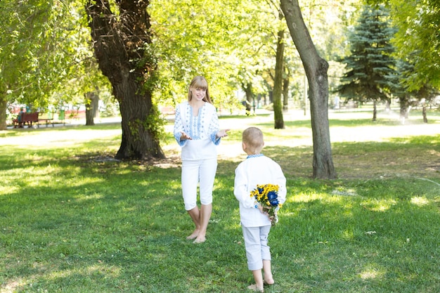 男の子が花束を持って公園を歩いています。