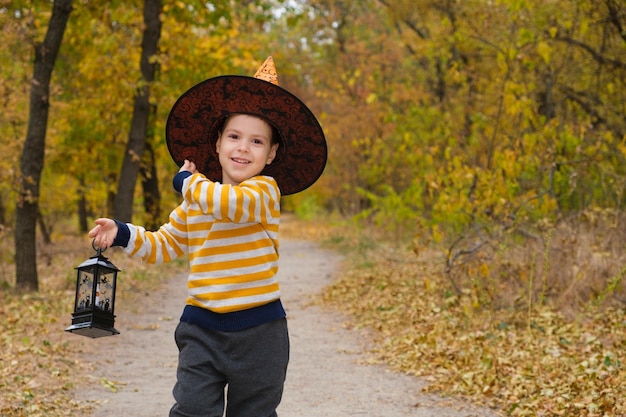 A boy walks with a lantern in the forest