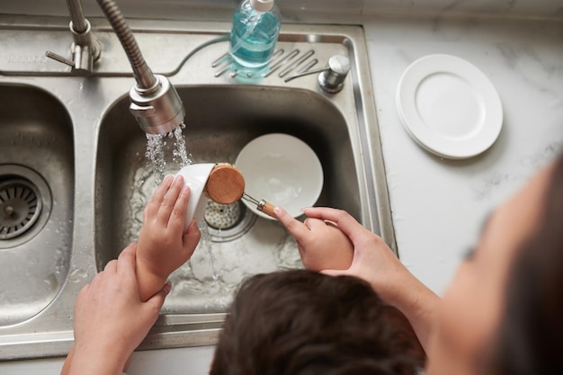 Boy Washing Dishes with Kitchen Brush