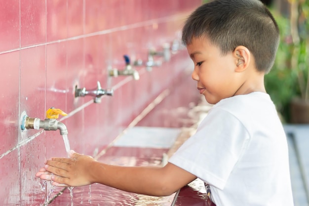 Photo boy washing hands in sink