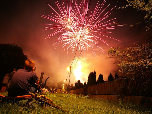 boy watching firework display at night