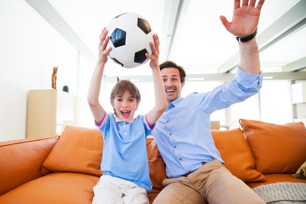 Ragazzo che guarda la partita di calcio con il padre