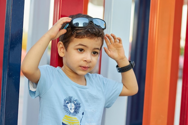 A boy wearing a blue shirt with a lion on it