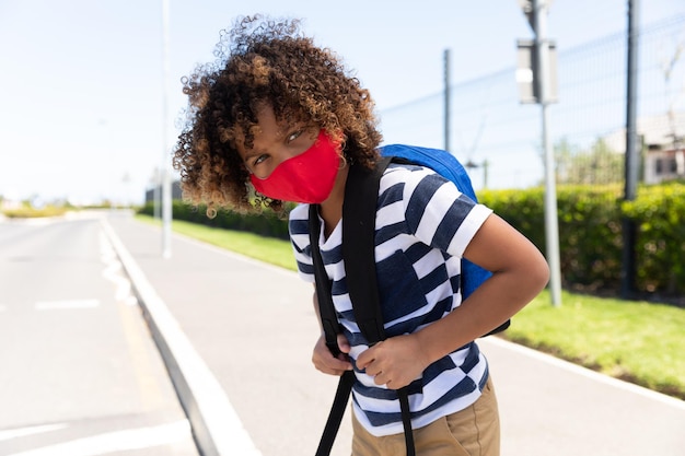 道路に立つフェイスマスクをした少年