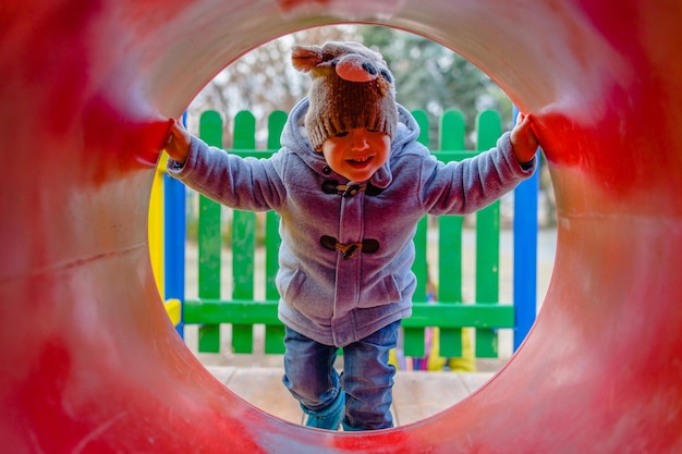 Photo boy wearing warm clothing while playing at playground