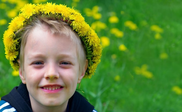 A boy wearing a yellow hat with a yellow flower in the background