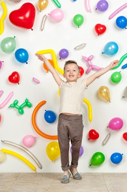 Ragazzo su sfondo bianco con palloncini colorati