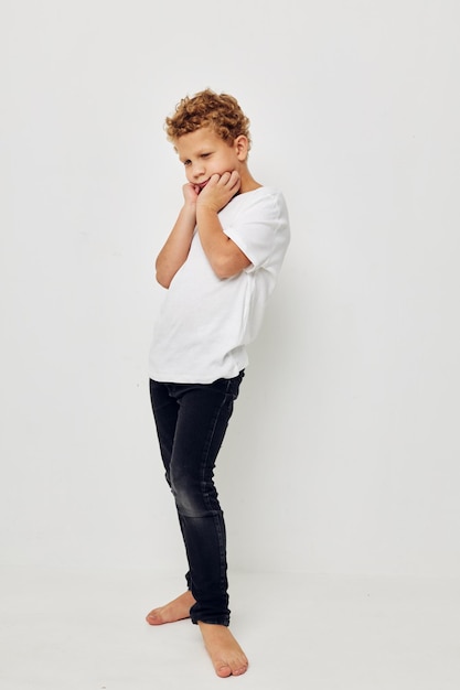Мальчик в белой футболке босиком в полный рост