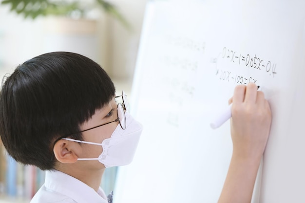 一生懸命勉強して数学の問題を解く少年