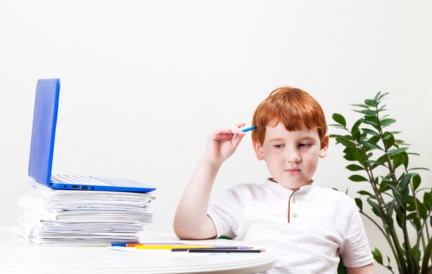 A boy who studies at home during the closing of schools in the period of an epidemic or pandemic, modern technologies are used in his studies, computer closeup