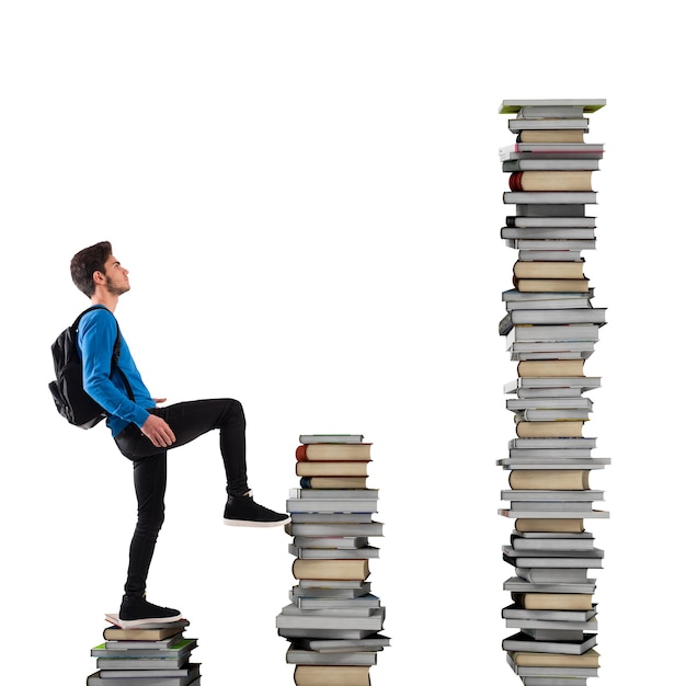 Boy with backpack climbs a books scale