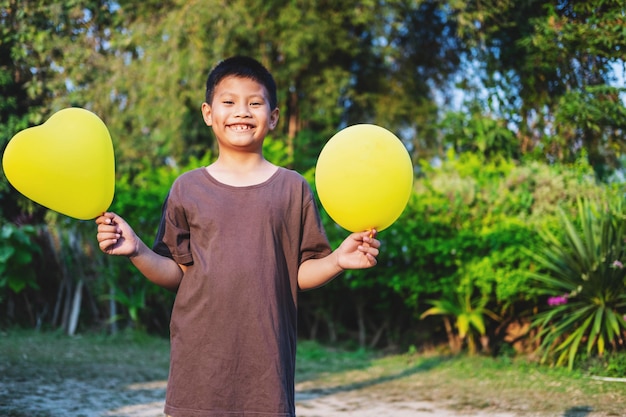 Boy with balloon on color. Birthday celebration