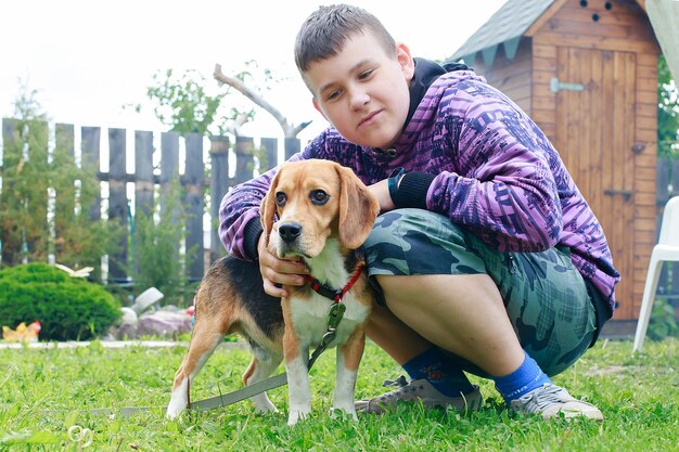 田舎でビーグル犬と一緒の少年