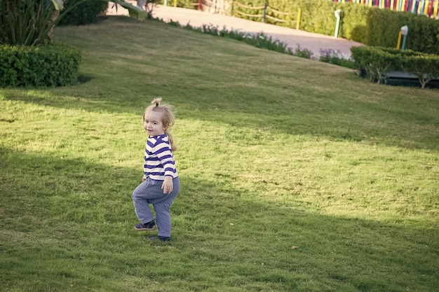 Photo boy with blond hair run on green grass