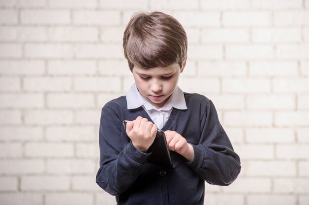 白い背景の上の本を持つ少年