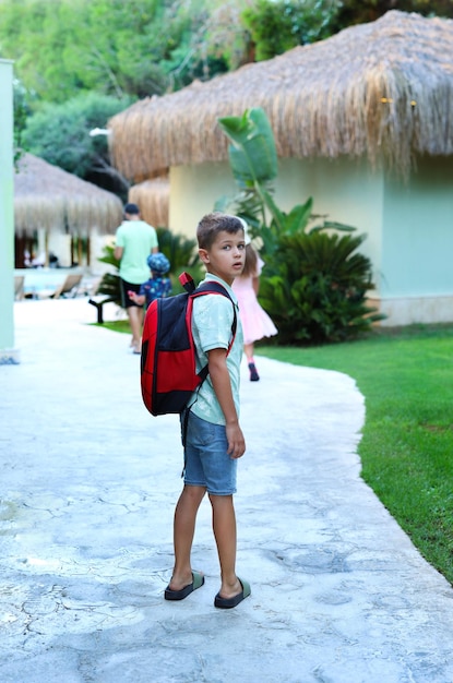 A boy with a briefcase walks and turns around