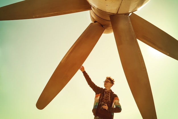 Boy with camera touches huge aircraft propeller