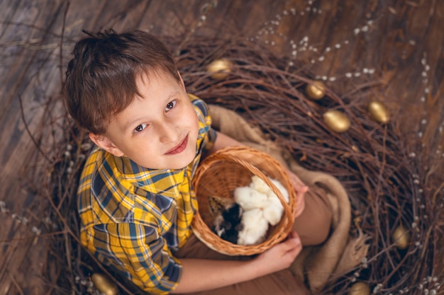 巣の中の鶏を持つ少年