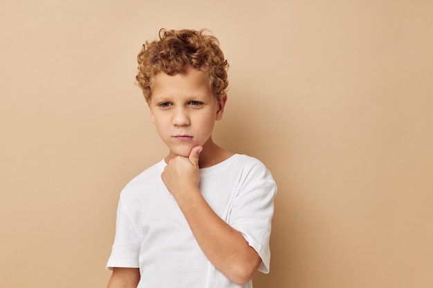 Boy with curly hair in a white tshirt posing