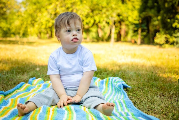 Boy with disability looking away while sitting on field