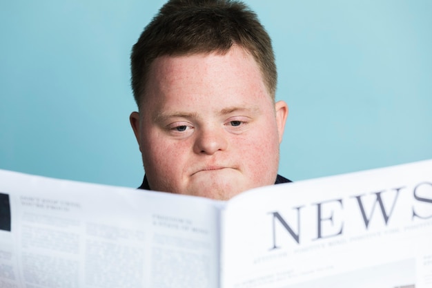 Ragazzo con sindrome di down che legge un giornale durante la pandemia di coronavirus