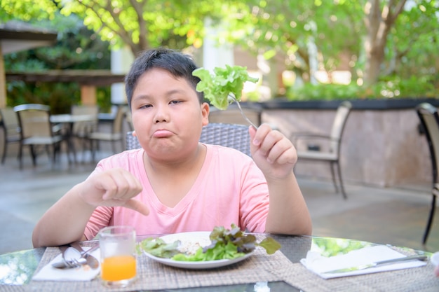 Boy with expression of disgust against vegetables 