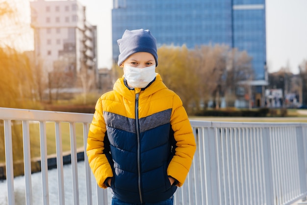 A boy with face mask stands in the street