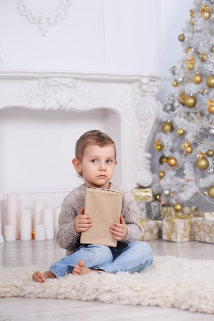 Boy with gifts under the Christmas tree