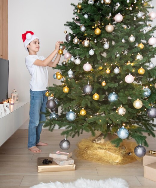 Il ragazzo con i regali gioca vicino all'albero di natale