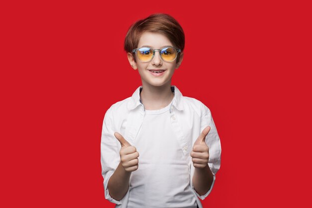 Фото Мальчик в очках жестикулирует знаком