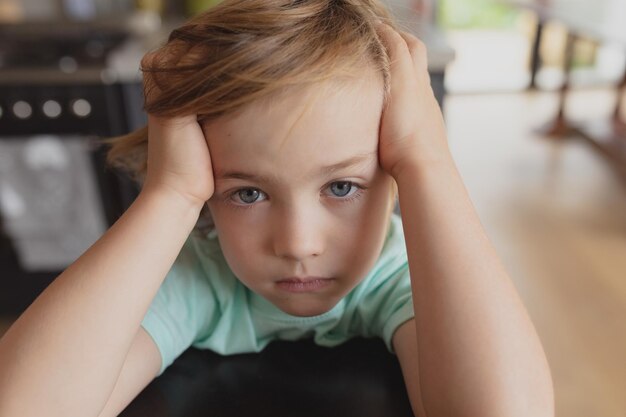 写真 カメラを見ている頭の上に手を置いた少年