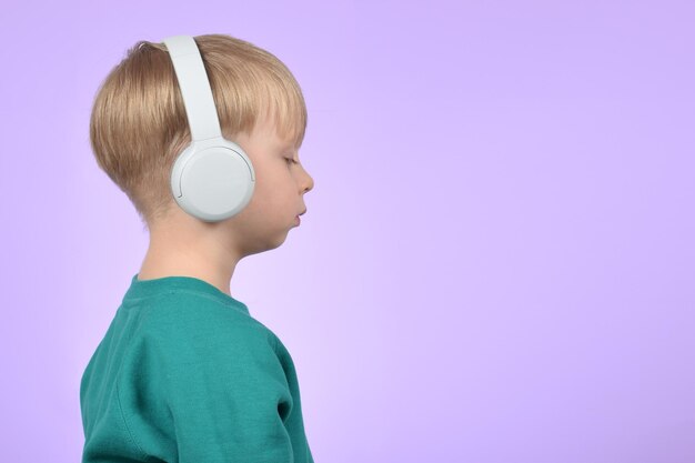 A boy with headphones on and a purple background