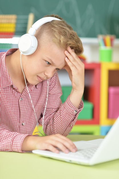 Boy with headphones using laptop