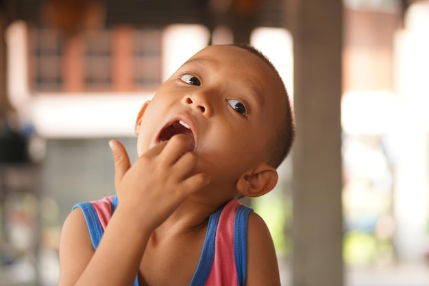 A boy with his hand picks up food scraps in his mouth