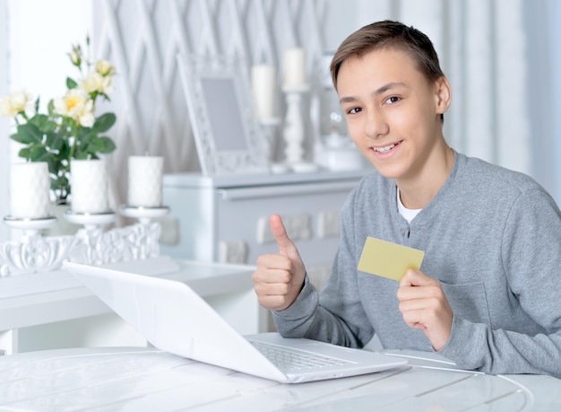 Boy with laptop and credit card