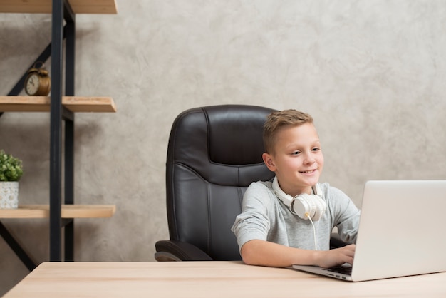 Boy with laptop in office