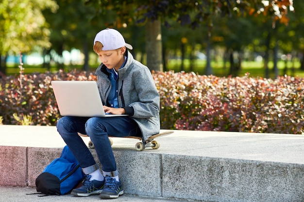 Boy with laptop outdoors