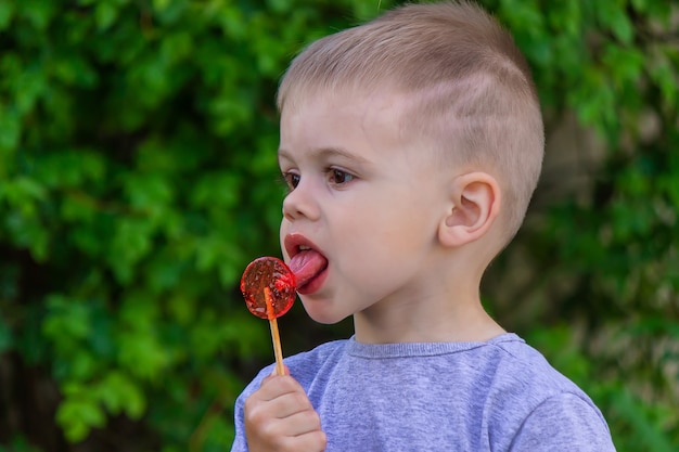 Boy with a lollipop on a green surface