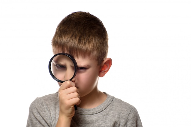 Boy with a magnifying glass in his hands