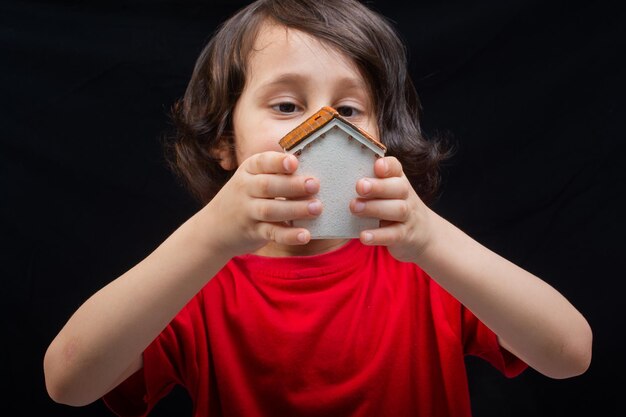 Boy with model house in hand as Property and insurance concept