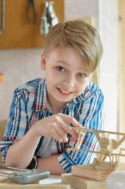 Boy with model of ship and handsaw