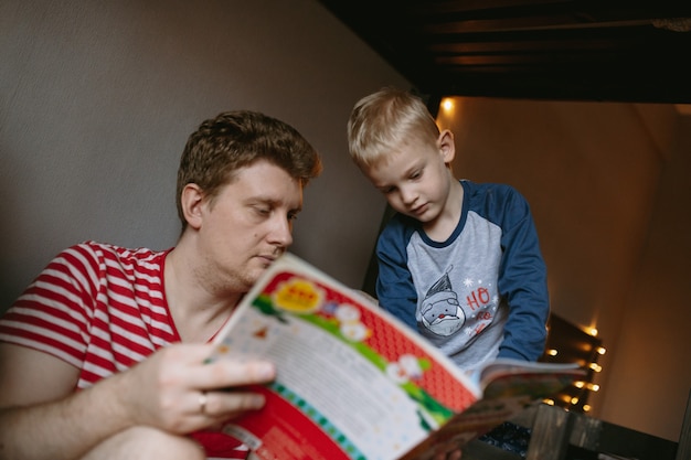 クリスマスの本を読んでいる母親と少年