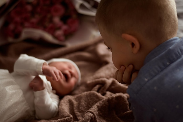 a boy with a newborn baby the boy looks at the baby