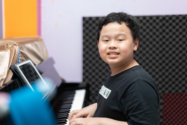 Photo boy with piano look at camera