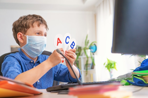 Boy with protective mask doing his homework