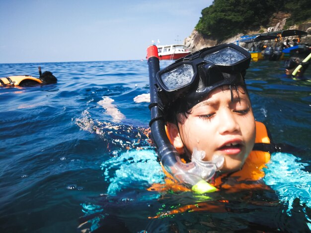 Photo boy with scuba mask swimming in sea