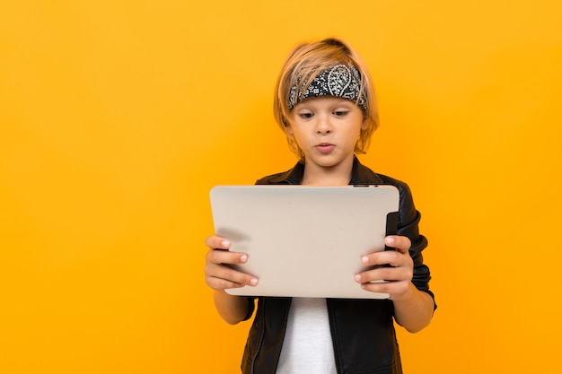 Boy with a tablet on yellow