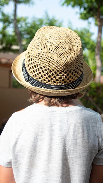 Boy with yellow straw hat on vacation at a campsite