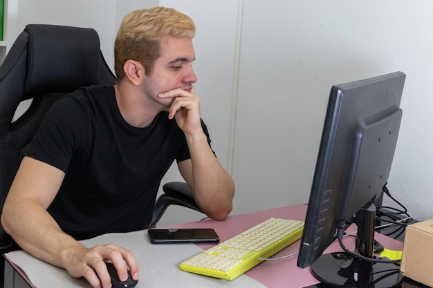 Boy working in the office on the computer with a concentrated\
face